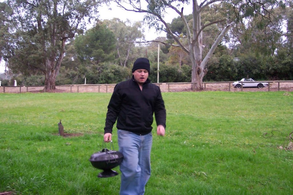 Man carrying mini Weber BBQ