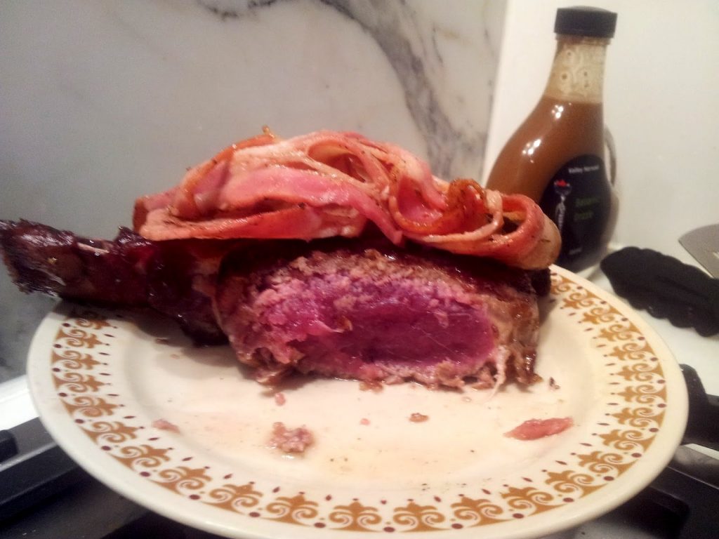 bleu ribeye steak with bacon on top