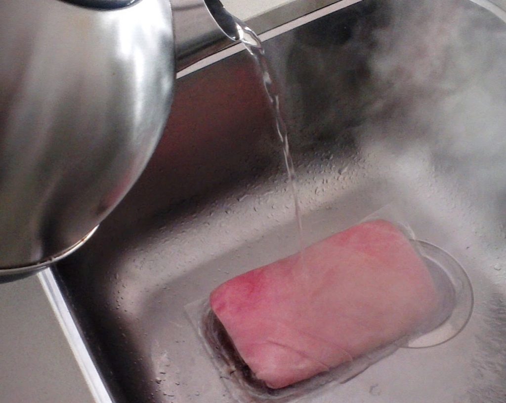pouring boiling water on pork belly