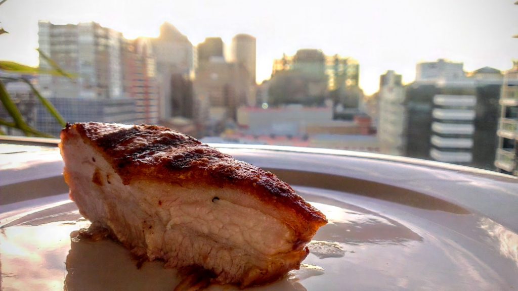 crispy pork belly and city skyline background
